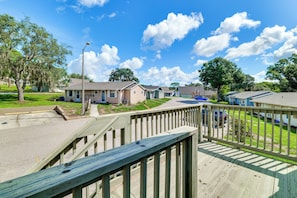 A residential area with houses, a street, and a wooden deck. - Sun-Kissed Cottage: Lake Access, 14 Mi to Disney (Clermont)