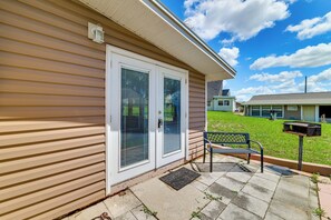 A residential building with a beige siding exterior, a front door with a glass panel, and a bench outside. - Coconut Cottage: Community Amenities, Near Disney (Clermont)