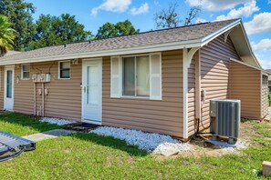 A single-story mobile home with a front door, two windows, and an attached air conditioning unit. - Coconut Cottage: Community Amenities, Near Disney (Clermont)