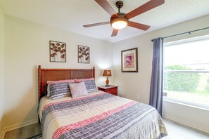 A bedroom with a bed, a ceiling fan, and two wall-mounted pictures. - Spacious 4BR w/ South-Facing Pool/Spa: Disney 11Mi (Clermont)