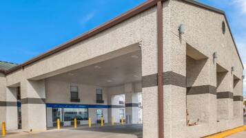 A building with a flat roof, large windows, and a covered entrance area.