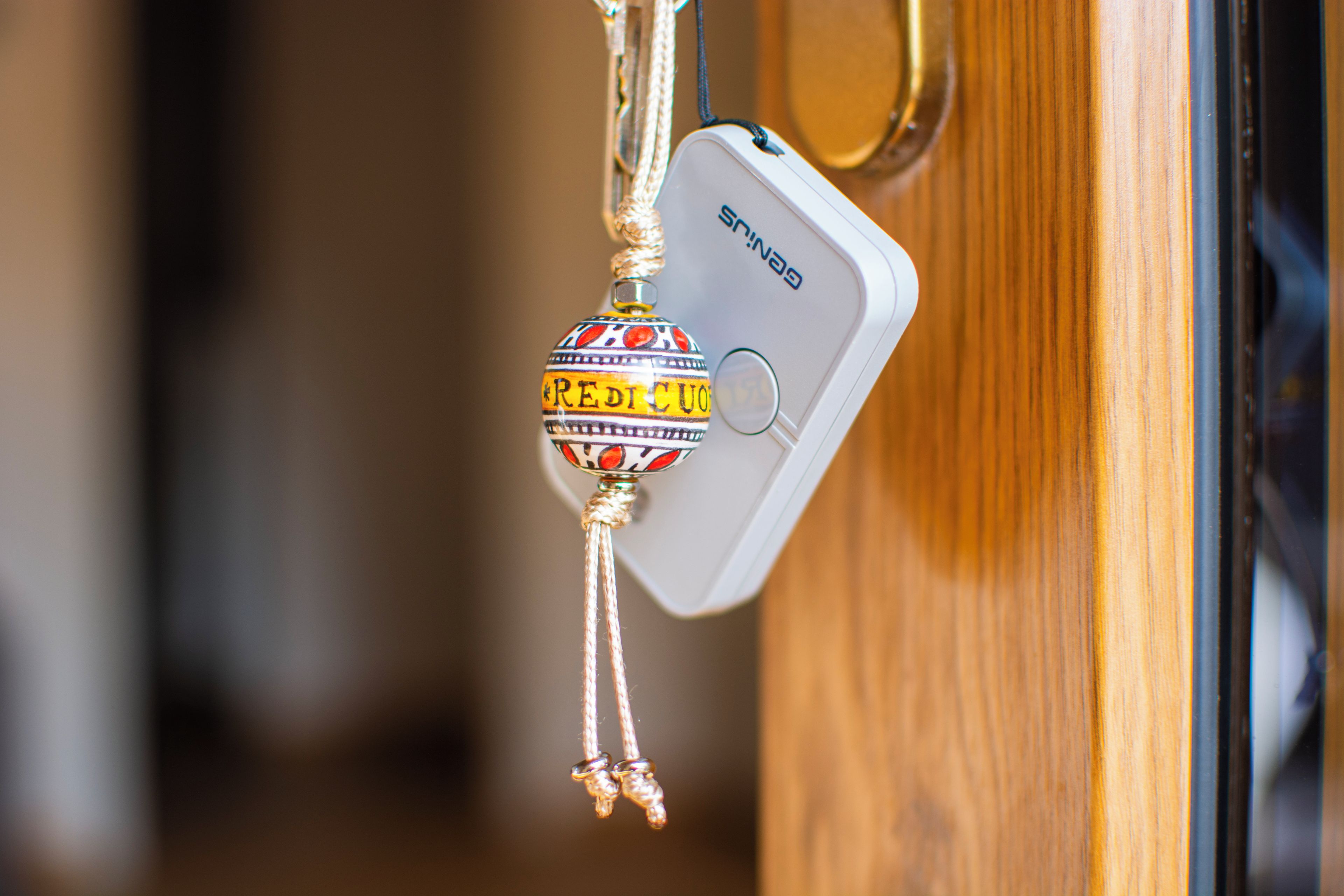 A door handle with a decorative ornament hanging from it.