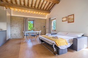 Un dormitorio con cama, mesita de noche y ventana.