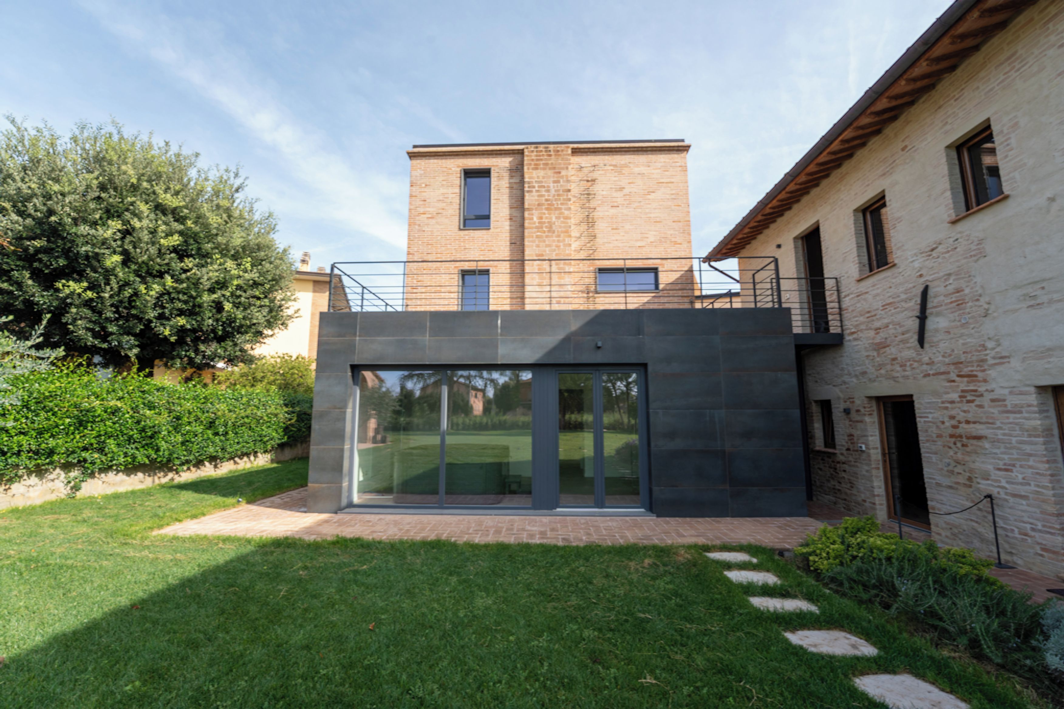 A modern building with a flat roof, large glass windows, and a brick facade.