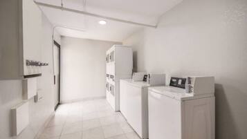 A laundry room with a washing machine, dryer, and stacked cabinets.