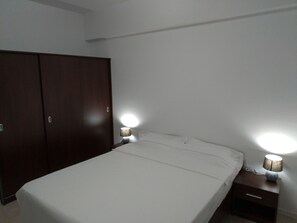 A bedroom with a bed, two bedside tables with lamps, and a wardrobe. - Apartments Lucia (Mamaia-Sat)