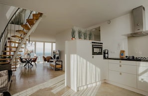 A modern kitchen with a built-in oven, a gas stove, and a stainless steel range hood. - Luxury penthouse Shrimp in Egmond aan Zee for 5 guests, with 3 bedrooms, two levels and panoramic sea views. (Egmond aan Zee)