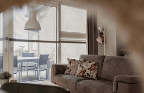 A living room with a sofa, a table, and chairs. - Sea-view apartment Sea Bass in Egmond aan Zee for 4 guests, with 2 bedrooms and two sunny terraces. (Egmond aan Zee)