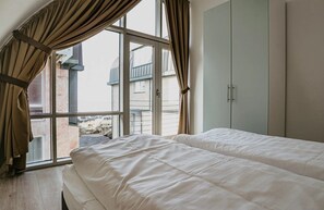 A bedroom with a large window, a bed, and a wardrobe. - Sea-view apartment Sea Bass in Egmond aan Zee for 4 guests, with 2 bedrooms and two sunny terraces. (Egmond aan Zee)