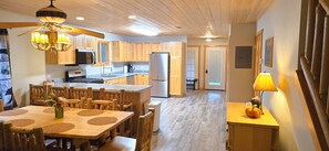A spacious kitchen with wooden cabinets, a central island, and a dining area with a table and chairs.