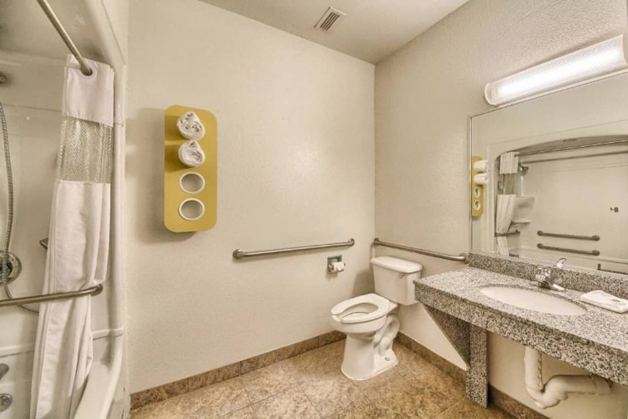 A bathroom with a toilet, sink, and shower area.