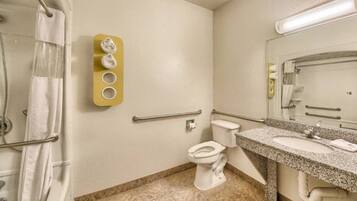 A bathroom with a toilet, sink, and shower area.
