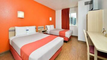 A hotel room with two beds, a desk, and a window with curtains.