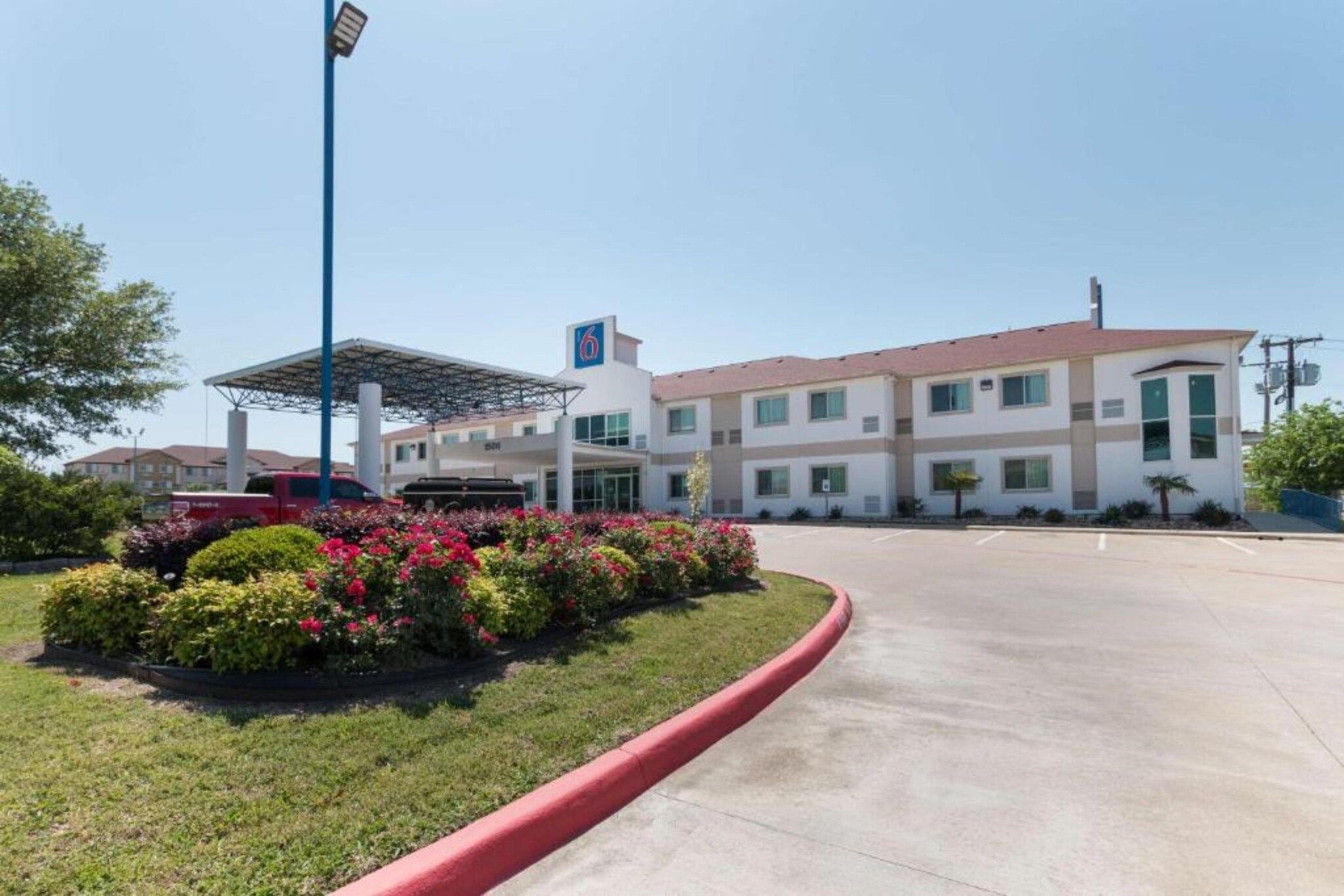 Un hôtel doté d’un parking, d’un espace de stationnement couvert et d’un bâtiment portant l’inscription « 6 ».