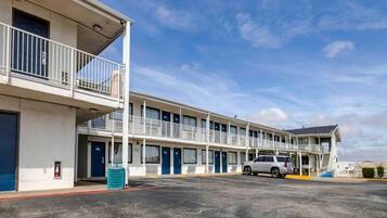 A motel with a two-story structure, multiple rooms, and a parking lot.