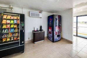 Zona de máquinas expendedoras con una máquina de aperitivos y una máquina de Dr Pepper.