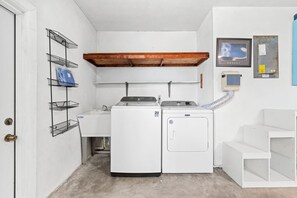 Handy laundry room with full-size washer, dryer and utility sink - Tiki Sunset: Banana Riverfront Home w/ Dock, Saltwater Pool, Hot Tub & Tiki Bar in Cocoa Beach (Cocoa Beach)