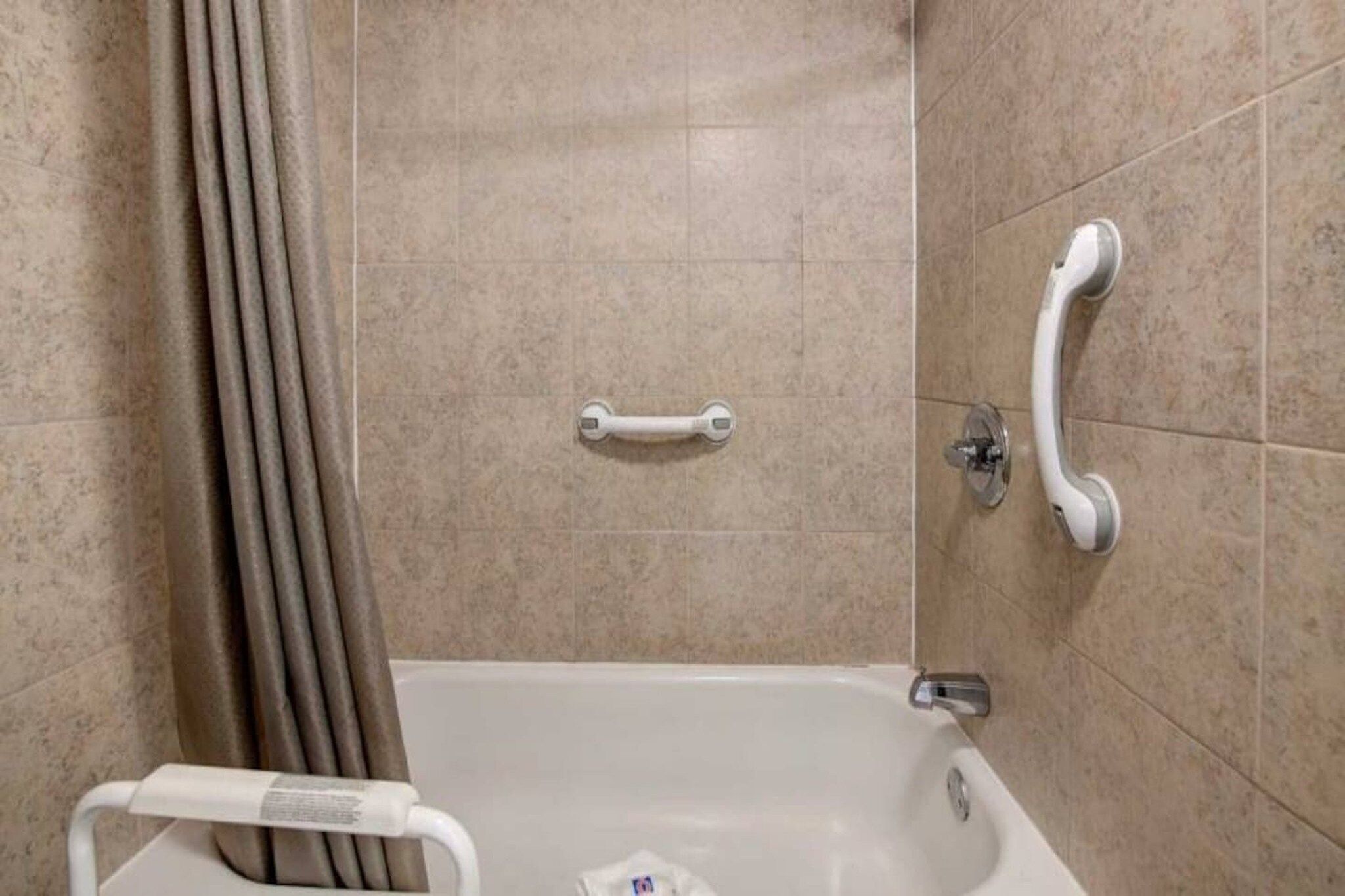 Ein Badezimmer mit einer Badewanne, einer Duschvorhang und einer Haltestange.