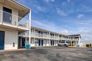 A motel with a two-story structure, multiple rooms, and a parking area.