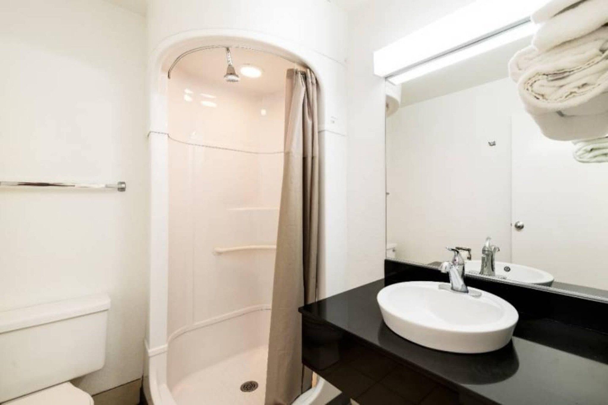 A bathroom with a shower, toilet, and sink.