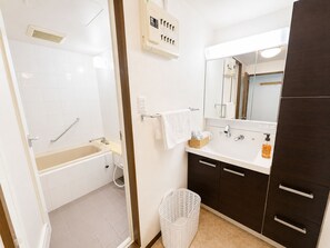 A bathroom with a bathtub, a sink, a mirror, and a towel rack. - Ocean Shinsaibashi Higashi (Osaka)