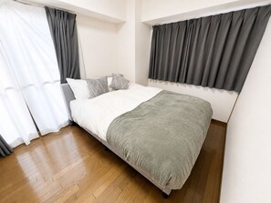 A bedroom with a bed, white curtains, and a grey blanket. - Ocean Shinsaibashi Higashi (Osaka)