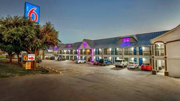 Un motel con diversi posti auto e un grande cartello d'ingresso.