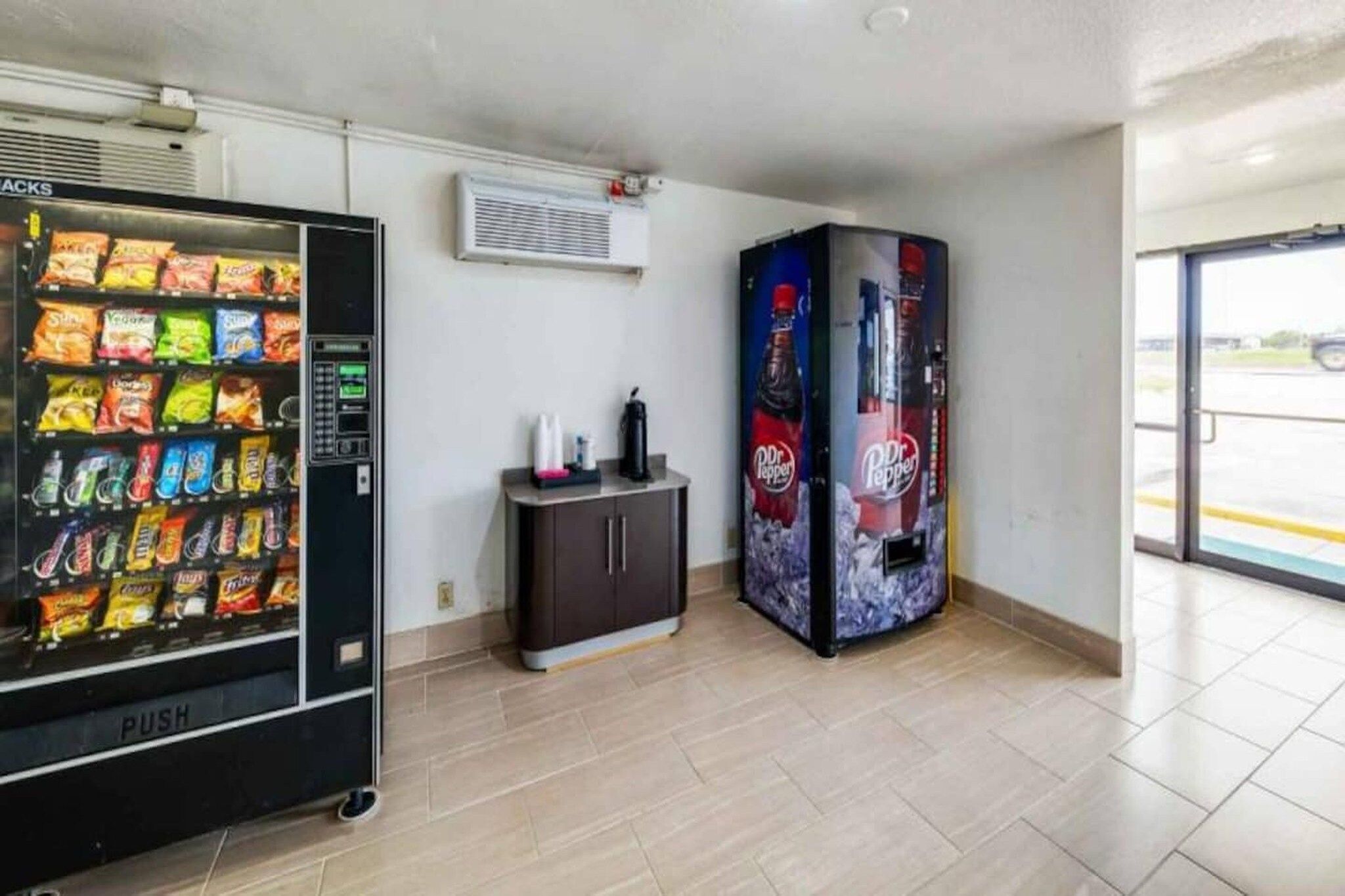 A vending machine area with a snack vending machine and a Dr Pepper vending machine.