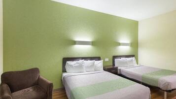 A room with two beds, a chair, and two wall-mounted lights.