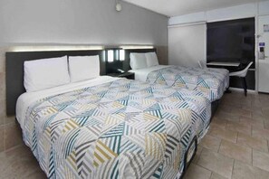 Una habitación de hotel con dos camas, un escritorio y una silla.