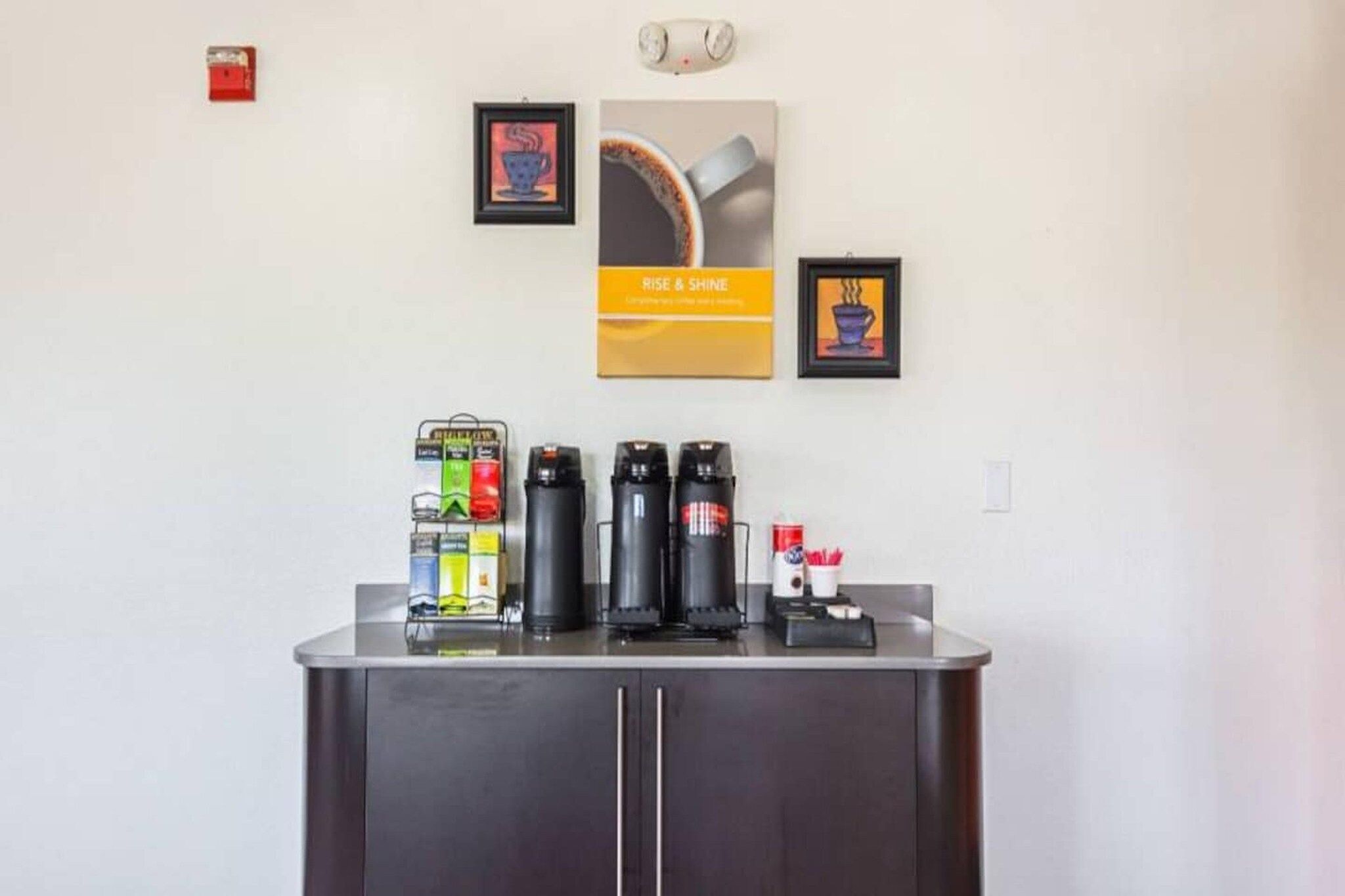A coffee station with multiple coffee makers and a selection of coffee pods.