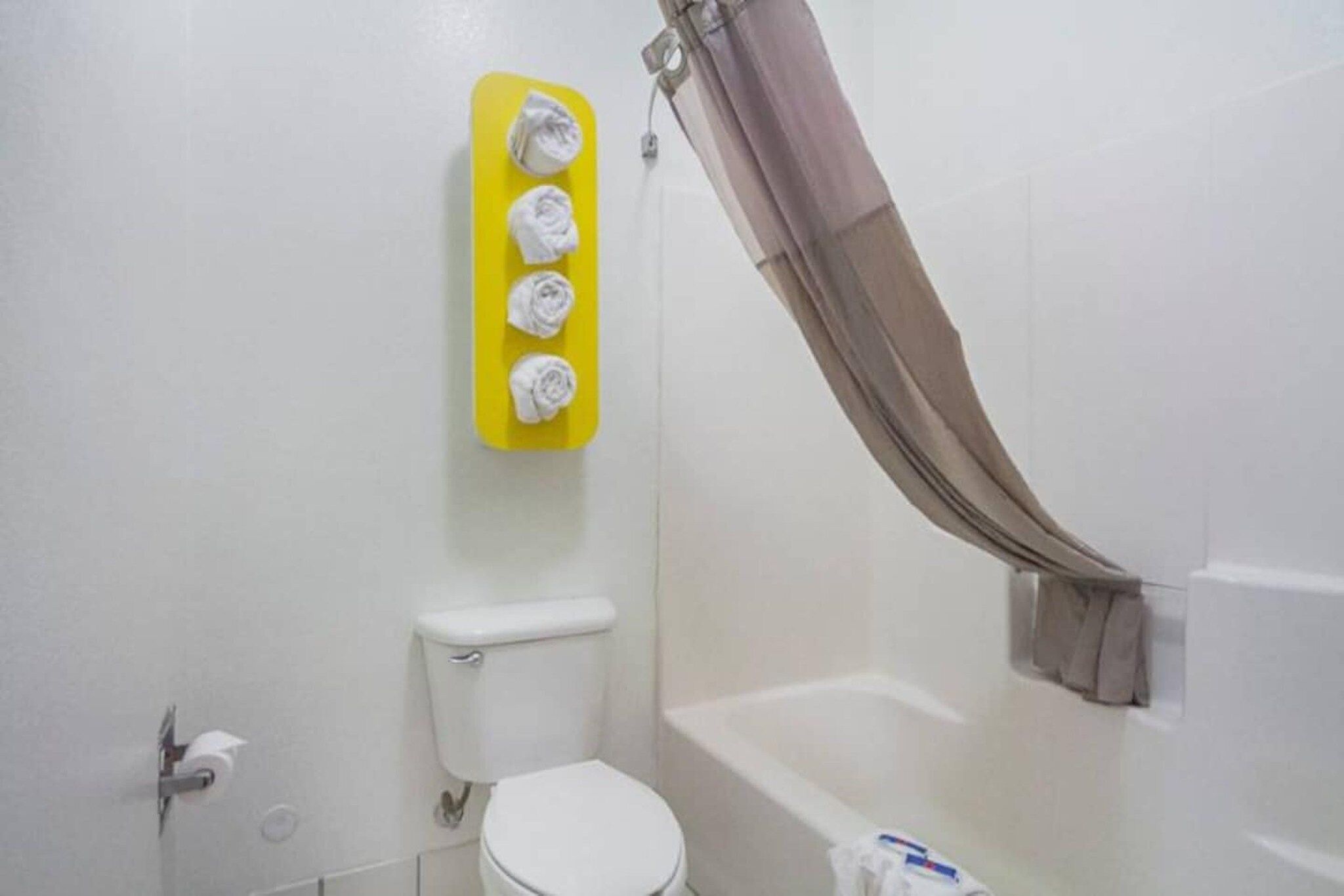 A bathroom with a toilet, a bathtub, and a shower curtain.