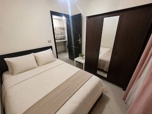 Ein Schlafzimmer mit einem Bett, einem Kleiderschrank und einem Spiegel.