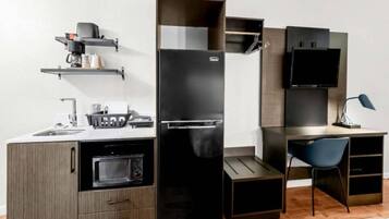 Eine kompakte Küche mit Mikrowelle, Kühlschrank und einer kleinen Spüle.