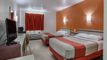 A hotel room with two beds, a desk, a chair, and a television.