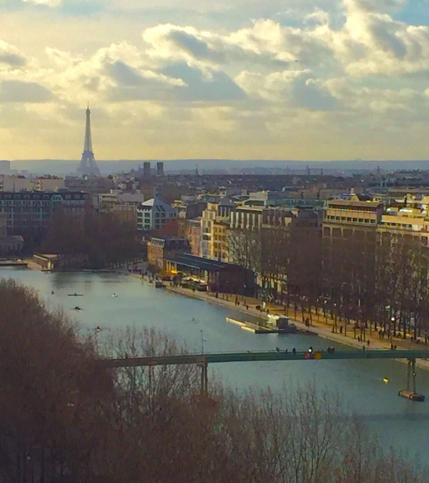 A river with buildings and a tower in the background.