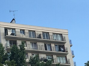 A multi-story building with balconies, a flat roof, and an antenna on the top. - Chic 75 m² Apartment with Views of the Canal and the Eiffel Tower (Paris)
