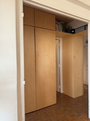 A room with a wooden wardrobe, a door leading to another room, and a wooden floor. - Chic 75 m² Apartment with Views of the Canal and the Eiffel Tower (Paris)