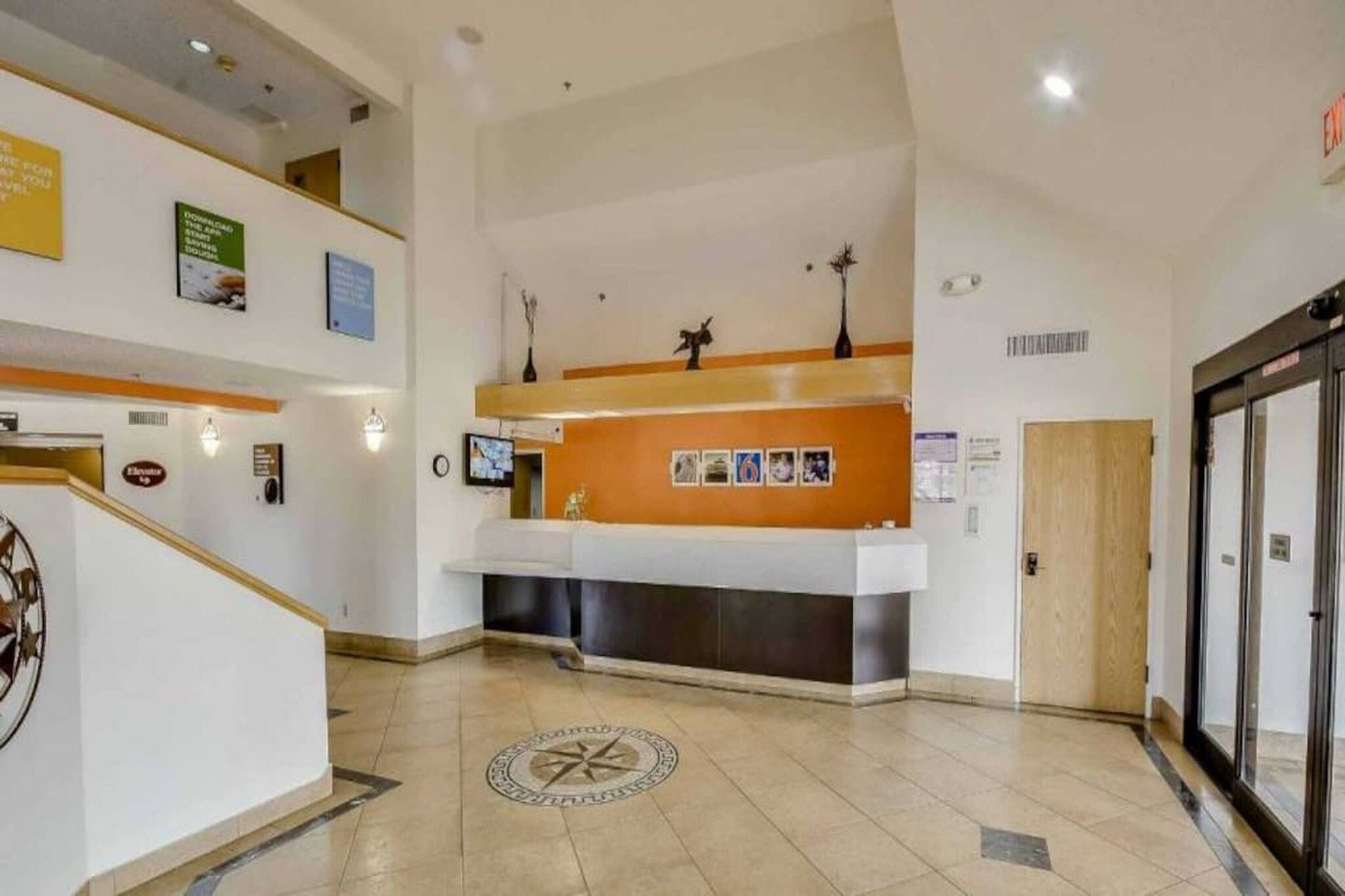 A reception area with a counter, a clock, and a door to the right.