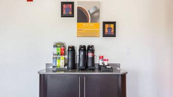 A coffee station with multiple coffee makers and a selection of coffee pods.