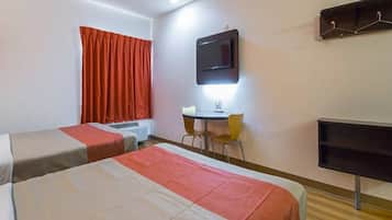 Habitación de hotel con dos camas, un escritorio, una silla, un televisor y una ventana con cortinas.