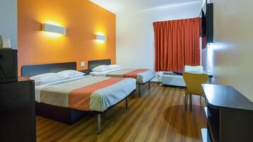 A hotel room with two beds, a desk, a chair, and a television.
