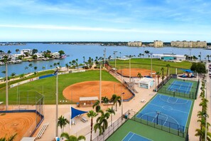 Ein Sportkomplex mit Baseballfeldern, Tennisplätzen und Blick auf das Wasser.