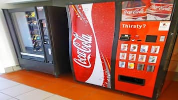 Un distributeur automatique de Coca-Cola proposant un assortiment de boissons et arborant une enseigne « Coca-Cola Classic ».