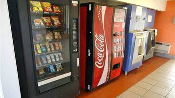 A vending machine area with a Coca-Cola branded machine and a snack vending machine.
