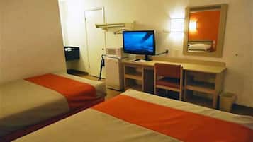 Une chambre d’hôtel avec deux lits, un bureau, une chaise, une télévision et un petit réfrigérateur.