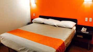 A hotel room with a bed, a nightstand, and a telephone.