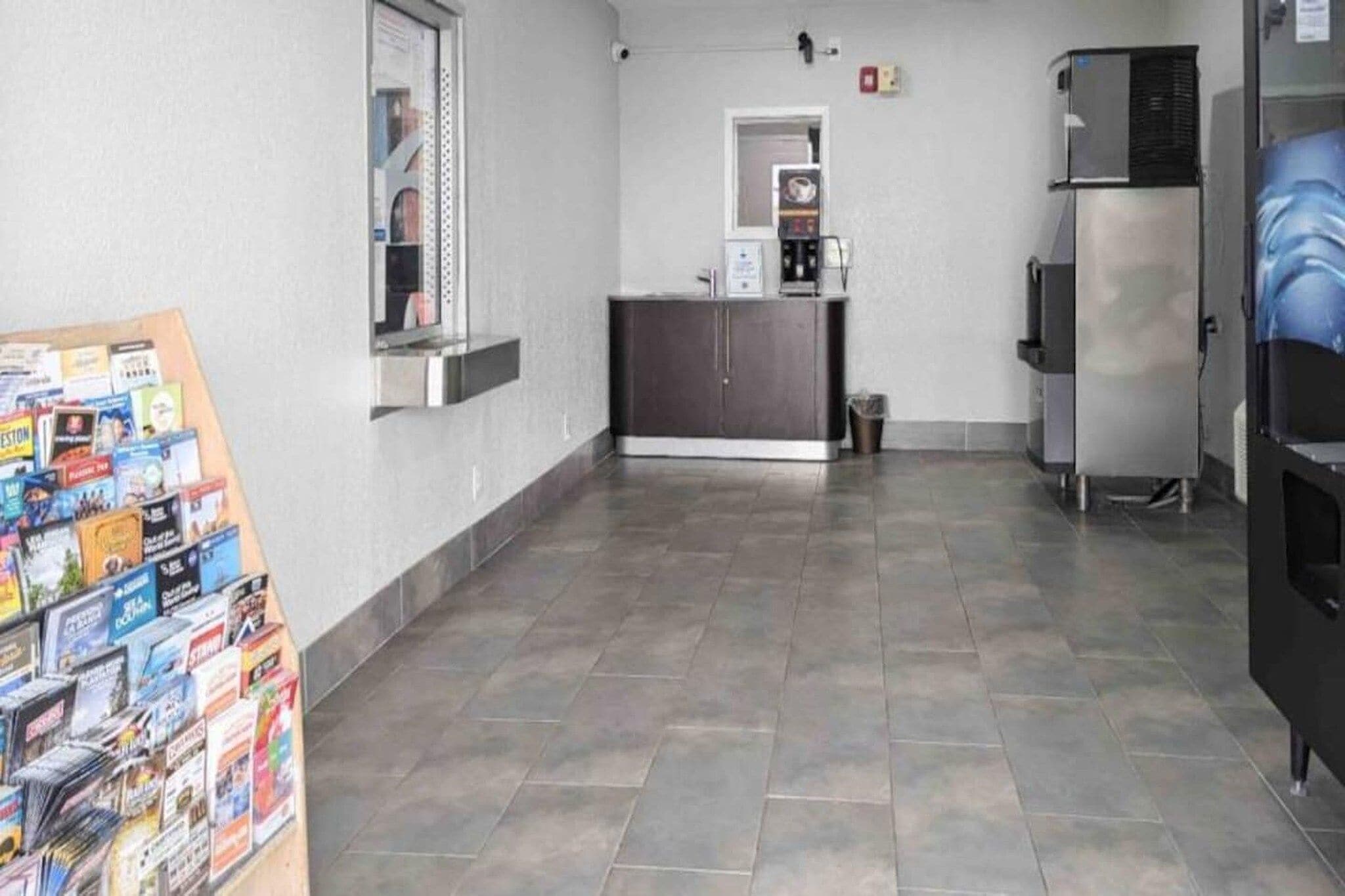 Eine Küche mit Fliesenboden, einem Kühlschrank, einer Mikrowelle und einer Kaffeemaschine.