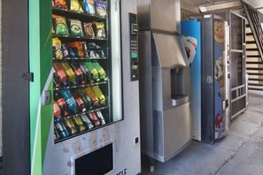 A vending machine with various snacks and drinks, a self-service beverage dispenser, and a trash bin. - 2 QUEEN BEDS | SMOKING KITCHEN (LANCASTER)