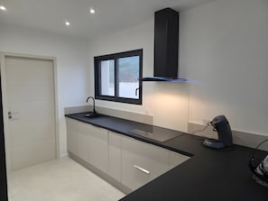 A modern kitchen with a black countertop, a window, and a built-in oven. - Holiday Home 'La Villa De Jade' with Mountain View, Wi-Fi and Air Conditioning (Murles)
